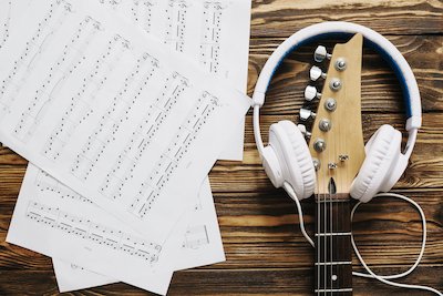 sheet music with guitar and headphones