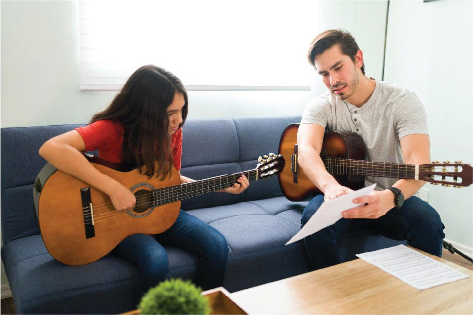 Guitar teacher, student, reading music